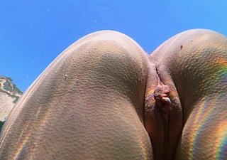 Стройная девушка плавает голой в море и мастурбирует свою киску